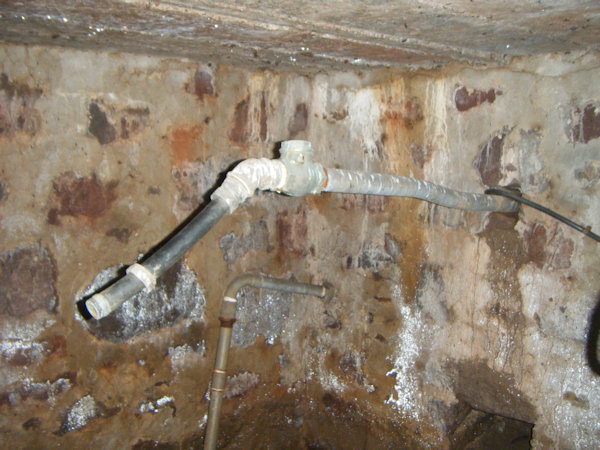 a large metal pipe in a stone wall